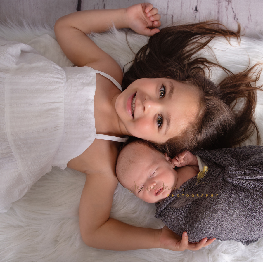 newborn baby and sibling pose, baby boy sleeping next to his sister