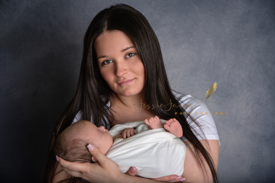 baby sleeping in his moms arms, mother and son newborn photo