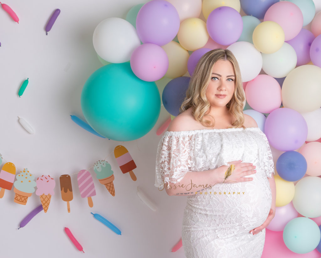 pregnant mother holding belly in ice cream themed backdrop