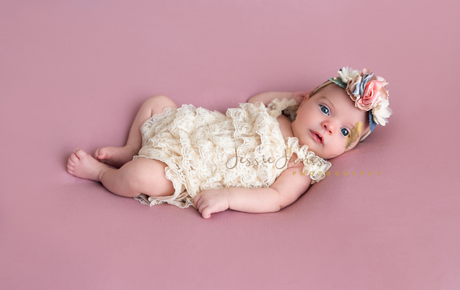 newborn baby on pink backdrop with her eyes open, newborn photography posing