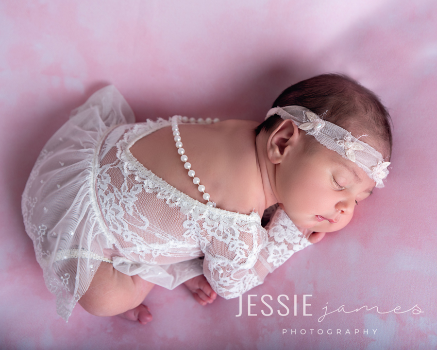 newborn baby girl sleeping wearing a white lace outfit with pearls, baby loss awareness
