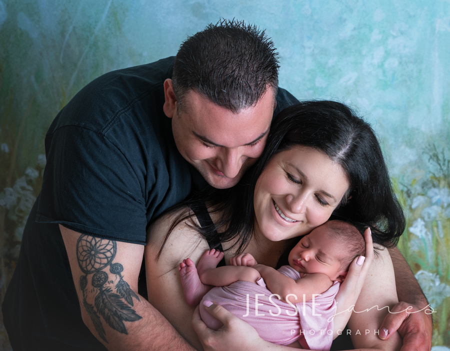 parents smiling with their newborn baby girl