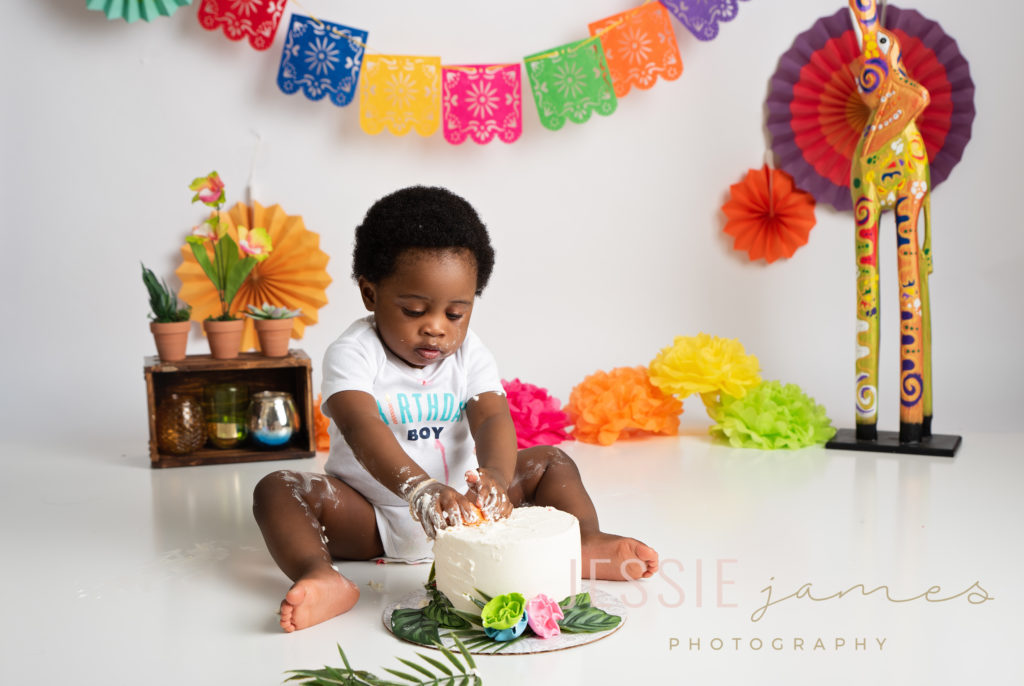 first birthday cake smash. baby boy smashing cake for his first birthday portrait session