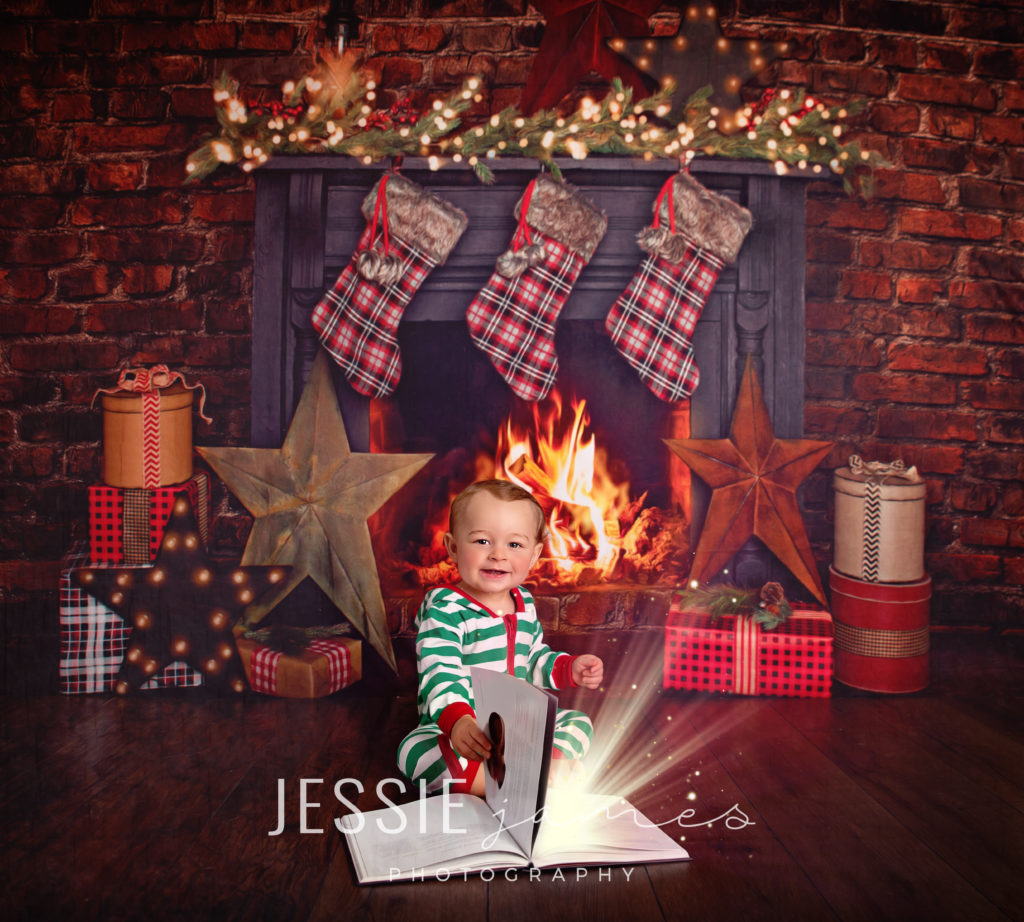 baby boy christmas photo, baby boy sitting in front of fireplace reading a magical christmas story