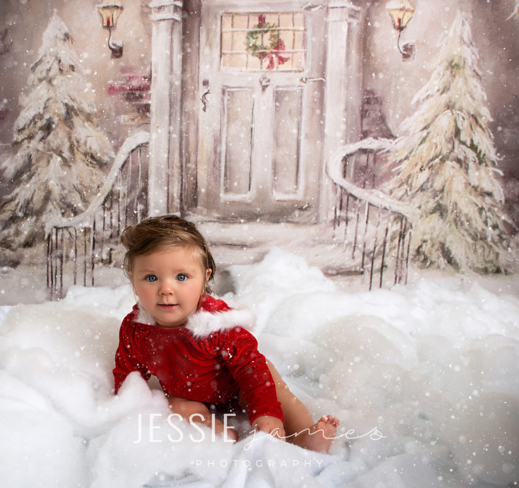 holiday mini session, baby girl sitting in the snow with a red fur romper