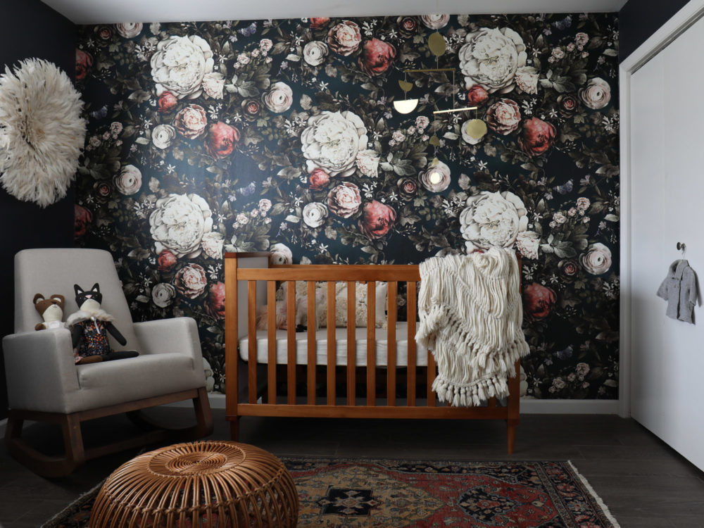 Dark floral wall in a nursery with wood accents. This is a nursery trend for 2020.  