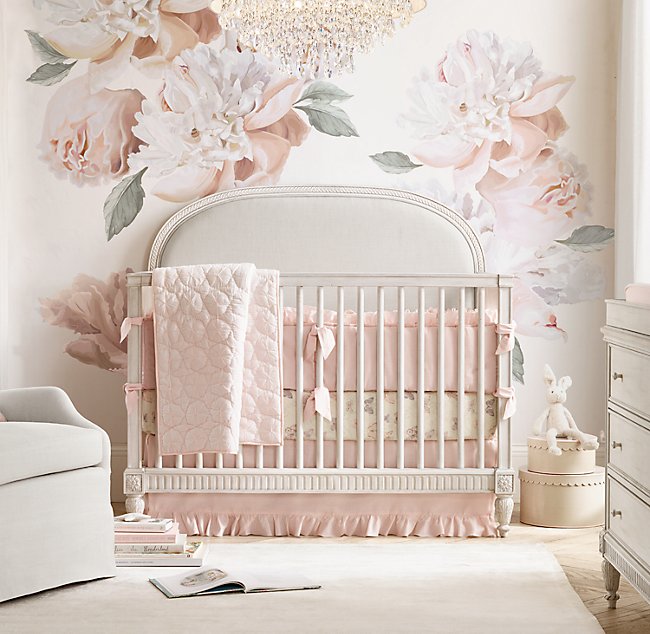 Oversized floral wall paper in a nursery with pink accents is a top trend for nurseries in 2020.