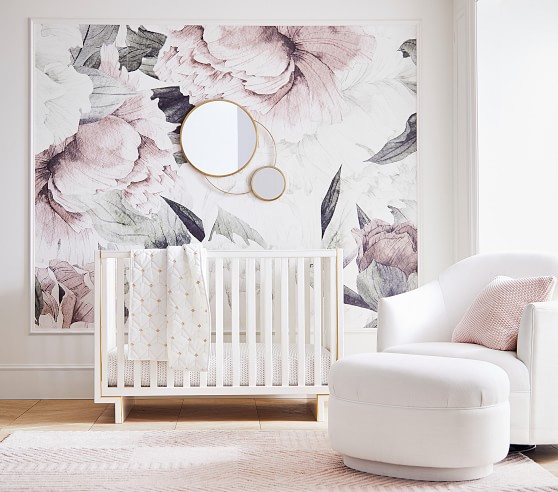 oversized floral nursery trend in 2020, nursery with large floral print wallpaper on the wall with a crib. 