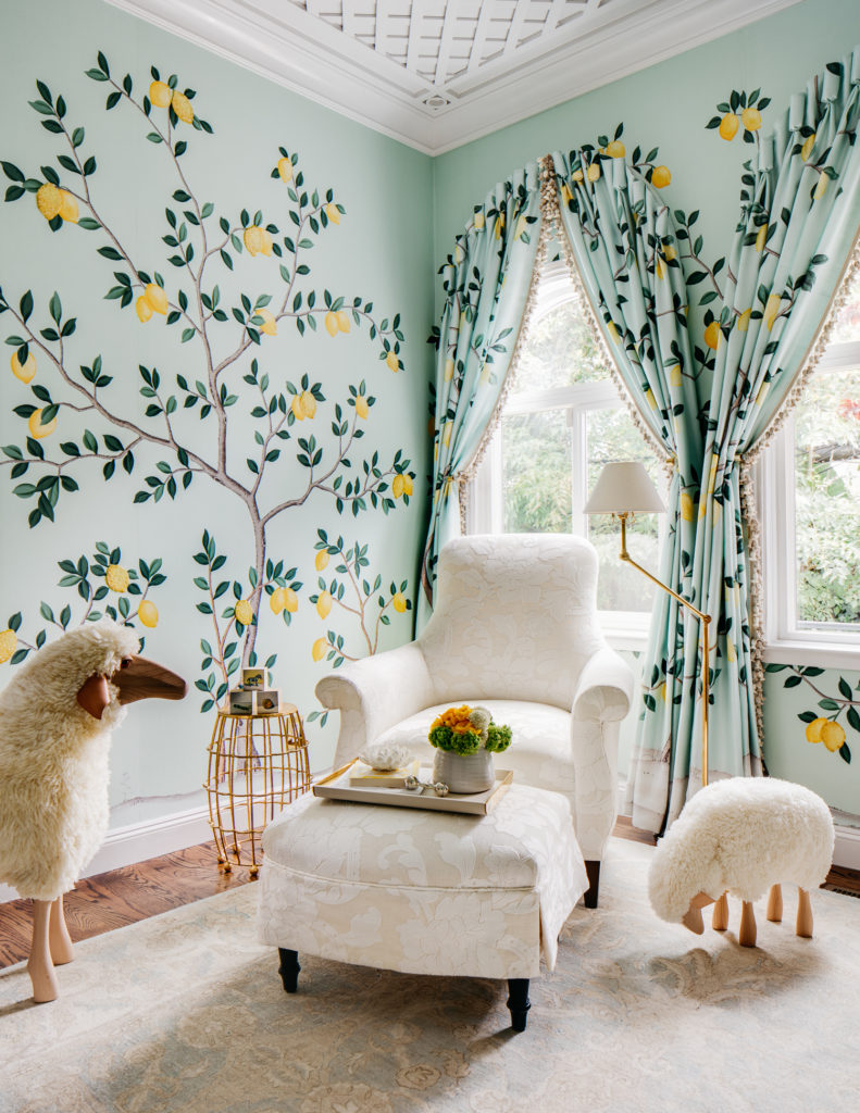 Lemon nursery theme, nursery wall painted mint green with lemon tree mural, matching mint green curtains with lemons. White arm chair to balance out the room.