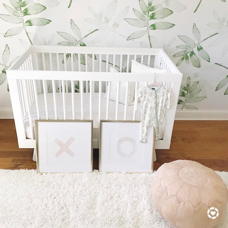 modern botanical nursery theme with bold leafy green wallpaper and a white crib.
