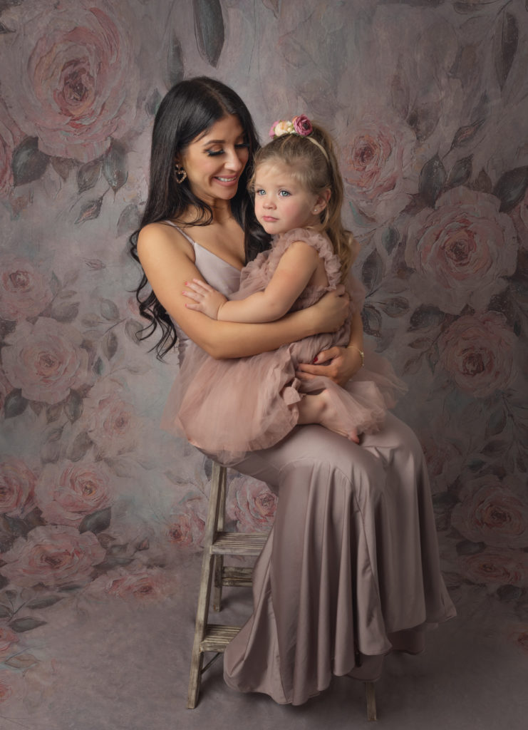 Photo of a mother holding and smiling at her young daughter.  Mommy & Me Photography session