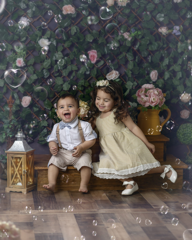 Spring Mini Session- a little boy and girl posing on front of a spring themed ivy wall.  