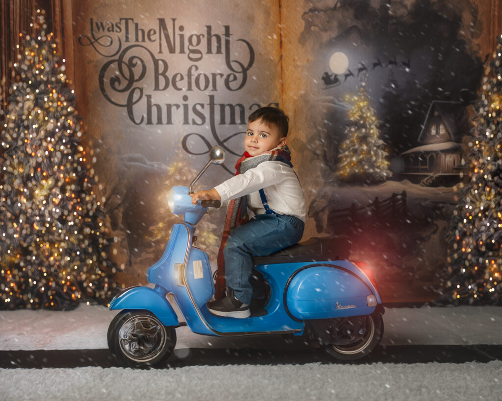little boy in front of a giant story book riding on a vespa