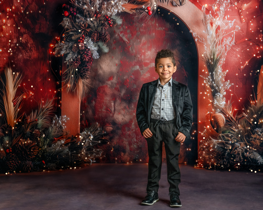 A little boy with his hands in his pockets posing in the Twilight Holiday Lights set, surrounded by twinkling lights and festive greenery