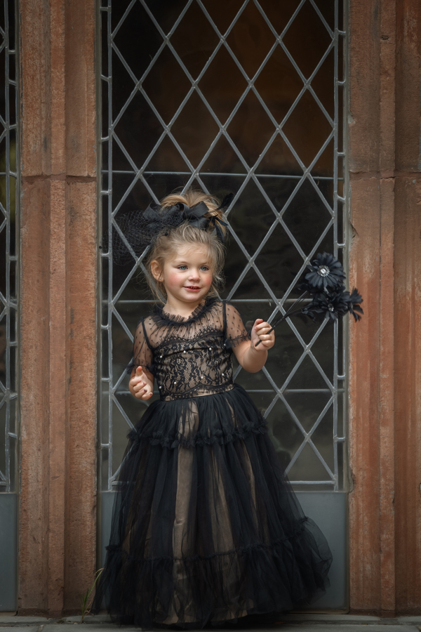 Child holding a flower and smiling in front of one of the buildings at Princeton University