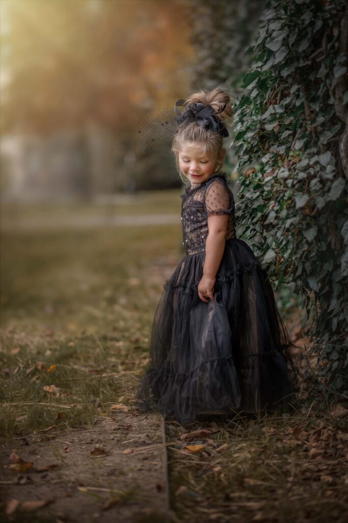 "Child looking down and smiling with ivy-covered building in the background at Princeton University."